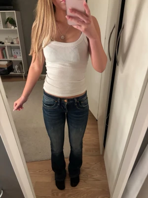 LTB low waist bootcut jeans - Säljer ett par klassiska blå LTB jeans i modellen Valerie med bootcut passform. Jeansen har låg midja och snygga slitningar framtill❤️storleken är W24 L32