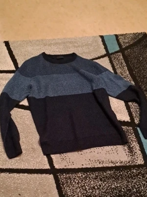 Blå stickad tröja från Rainbow -  Jag säljer en tröja i storlek M som är i mycket bra skick. Den är väl omhändertagen och ser nästan ny ut. Perfekt för dig som vill ha en bekväm och snygg tröja till ett bra pris.  Priset är 200 kr, vilket jag tycker är ett riktigt bra pris med tanke på skicket. Jag är öppen för snabba affärer!  Tveka inte att höra av dig om du är intresserad eller har några frågor. Först till kvarn gäller!