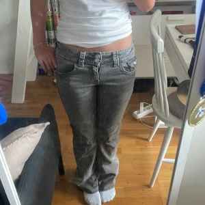 Grå bootcut jeans låg midja - Säljer ett par grå jeans med bootcut-modell och låg midja. Från ginayoung med storlek 158.💓