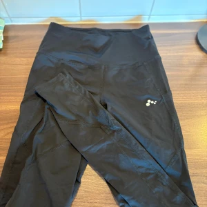 Helt nya Svarta träningstights från Only Play - Snygga svarta träningstights från Only Play med hög midja och diskret logga på benet. Tillverkade i stretchigt funktionsmaterial som passar perfekt för gym, löpning eller yoga. Tight passform och bekväma sömmar för maximal rörelsefrihet. Helt nya 