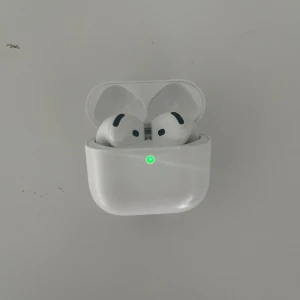 Apple AirPods Pro trådlösa hörlurar - Säljer ett par vita Apple AirPods Pro med laddningsetui. De har en stilren och kompakt design med silikonpluggar för bra passform. Perfekta för musik, samtal och träning. Laddningsetuiet har LED-indikator på framsidan.