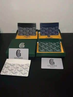 Goy4ard korthållare i flera färger - (Du får endast en plånbok och den vita är slutsåld) Snygga korthållare från Goy4ard i svart, blå, grön och vit. Klassisk och ikonisk design med Goy4ards signaturmönster och flera fack för kort. Tillverkade i exklusivt skinn med präglat mönster. Perfekt accessoar för dig som vill ha stilren och lyxig känsla.