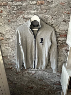 Ljusgrå stickad tröja Hackett London - Mycket fint skick, inga defekter. Storlek XS passar dig som är mellan 178-188cm. Nypris ca 2000. Modellen är 185 cm, 79 kg. Skriv för mer information!🤝