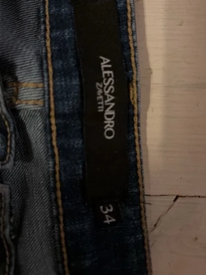 Blå jeans från Alessandro Zavetti - Klassiska blå jeans från Alessandro Zavetti med snygga kontrastsömmar och femficksdesign. Jeansen har en rak passform och är gjorda i slitstarkt denimtyg som ger en tidlös look. Perfekta för dig som gillar italiensk stil och detaljer.