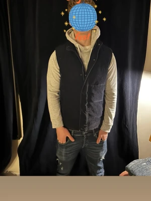 Mörkblå manchester väst - Säljer en mörkblå dunväst i manchestertyg med dragkedja och tryckknappar framtill. Västen har hög krage och två fickor på sidorna. Snygg och enkel design som funkar till hoodie eller tröja under. Perfekt för lager-på-lager och streetwear-vibe. Priset är som alltid diskuterbart mina vänner❤️🚀