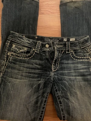 Miss Me blå jeans med detaljer - Säljer ett par blå Miss Me jeans med ljusa kontrastsömmar och snygga glittrande nitar på fickorna. Jag är 165 lång och jeansen passar mig i längd,  de är dock insydda i midjan (sista bilden) då de var lite stora men det går säkert att enkelt sprätta upp sömmen om man vill det! Pris går att diskutera 💞