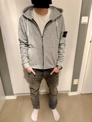 Grå hoodie från Stone Island M - Snygg grå hoodie från Stone Island med klassisk logopatch på vänster ärm. Passformen är för S-M, men den är för stor för mig eftersom jag har mindre storlek. 