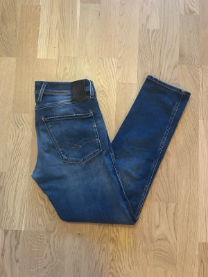 Blå Replay Anbass jeans W31 L30 - Jag säljer dom här riktigt snygga Replay Anbass jeansen i storlek W31 L30. De är i fint skick och är inte använda mycket. De har snygga slitningar vid fickorna. Tveka inte att höra av er!                   Mått: Längd=97cm. Midja=40cm