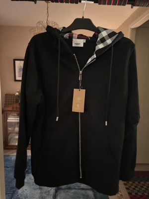 Burberry zip hoodie - En fin ny svart burberry zip hoodie oanvänd då den var lite för stor för mig. Den är lite stor i storleken passar som en storlek M ungefär.   inga återbetalningar