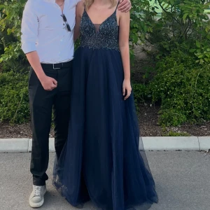 Marinblå balklänning med paljetter💗  - Elegant marinblå långklänning med glittriga paljettdetaljer på livet och tunna axelband. Klänningen har en v-ringad design och ett flödande kjolparti i tyll som ger en drömlik känsla. Perfekt för speciella tillfällen eller på bal 🥰endast använd en gång och nypris är 4800kr