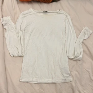 Vit långärmad tröja från Gina Tricot - En basic vit långärmad tröja från Gina Tricot med slits i sluten av ärmen, Tröjan har rund halsringning och en smal passform som sitter snyggt på kroppen. Tvättar såklart innan jag skickar