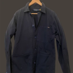 Ralph lauren - Snygg mörkblå overshirt från Polo Ralph Lauren med knappar framtill. Den har en klassisk krage och tre praktiska fickor. Perfekt för lager-på-lager-stil.