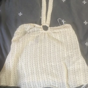 Beige stickad topp - Superfin beige sommar/fest topp i stickat material med snyggt mönster och breda axelband som möts i en ring. 