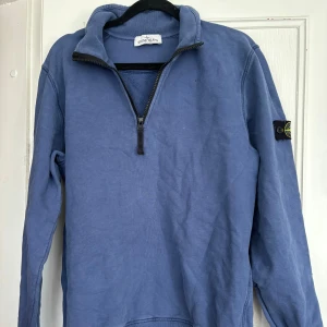 Blå half zip tröja från Stone Island - Säljer en blå långärmad tröja från Stone Island Junior med klassisk logga på ärmen.