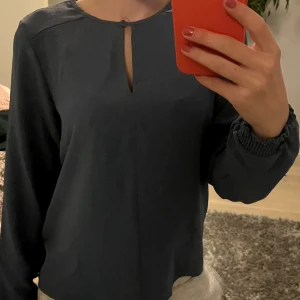 Blå blus från Vero Moda XS - Säljer en stilren blå blus från Vero Moda i storlek XS. Blusen har långärmade ärmar med smock vid handlederna och en liten slits framtill vid halsen. Perfekt för dig som gillar en enkel men snygg look.