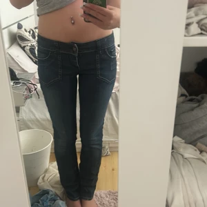 Mörkblå straight/skinny jeans med broderi - Säljer ett par mörkblå straight jeans med snygga kontrastsömmar och broderade bakfickor. Jeansen har låg midja och klassisk femficksdesign. Materialet är jeans med en lätt stretch för skön passform. Skulle du om dem till bootcut men min symaskin har gått sönder🌸💕