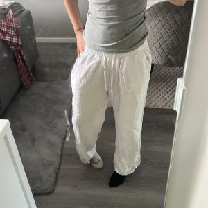Vita loose linnebyxor med snörning - Säljer ett par vita linnebyxor med avslappnad passform och resår i midjan med snörning. Byxorna har raka ben och är perfekta 💗