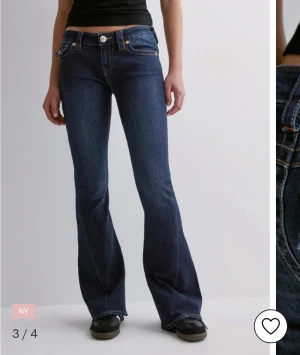 True Religion bootcut jeans mörkblå - Mörkblå bootcut jeans från True Religion med låg midja och klassiska kontrastsömmar. Snygga fickdetaljer bak med lock och silverfärgade knappar. Jeansen är mer sydda efter min längd ca 160 och det kostade o sy ner dom o har inte använt mycket för dom va tyvärr för stora i midjan drf priset