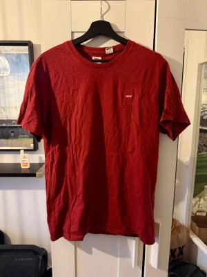 Röd Levi's t-shirt i bomull - Snygg röd t-shirt från Levi's med klassisk rund hals och liten logotyp på bröstet. Modellen är enkel och har korta ärmar, perfekt för dig som gillar stilrena plagg. Materialet är mjuk bomull som känns skönt mot huden.