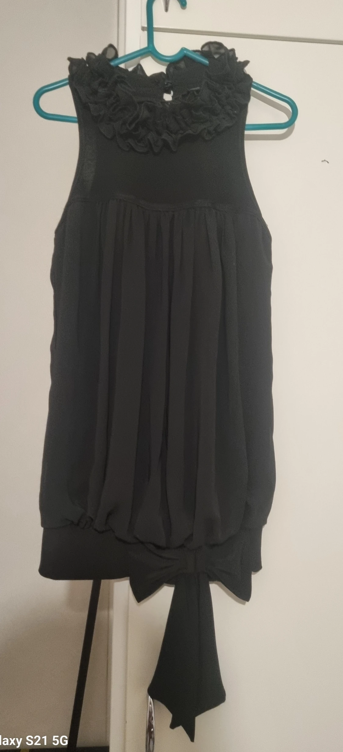 Svart blus med volang och rosett