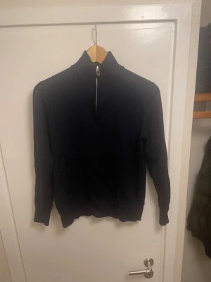 Merinoull half zip Sayless - Mörkblå långärmad tröja från Sayless i mjuk merinoblandning. Tröjan har en hög krage med half zip-dragkedja och ribbade muddar. Enkel och stilren design som passar perfekt till lager-på-lager under höst och vinter. Skicka dm om du har frågor eller behöver mer bilder.