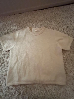 Vit kortarmad stickad i 158/164 - Säljer en vit kortarmad stickad tröja från Gina tricot i nytt skick. Aldrig använts