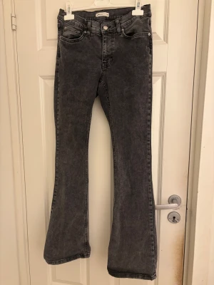 Grå bootcut jeans från Gina tricot - Säljer ett par gråa bootcut jeans från Gina Tricot i storlek 38. Dom är dock lite slitna där nere och har ett litet hål längst ner men de syns inte