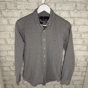 Ralph Lauren skjorta - Ralph Lauren skjorta i en unik grå färg. Stilren och tidlös modell som passar lika bra till vardag som till fest. Använd endast någon enstaka gång – i princip nyskick. Hör av dig vid intresse! 🙌
