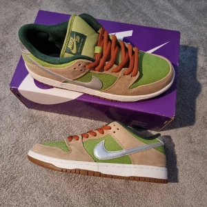 Nike SB Dunk Low escargot - Nike SB Dunk Low escargot med grön textil, beige mockadetaljer och silvrig swoosh.. Kommer med originalkartong. Aldrig använd.