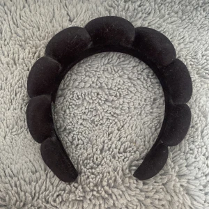 Svart vadderat diadem i sammet - Säljer ett svart diadem med vadderad, bubblig design som ger en cool statement-look. Diademet är klätt i mjuk sammet och har en unik form som verkligen sticker ut. Perfekt accessoar för att lyfta vilken outfit som helst.