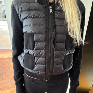 Svart Moncler cardigan  - Säljer en svart moncler cardigan i storlek S. Jackan är nästan helt oanvänd och därav i ett jätte fint skick. Jackan är köpt i moncler butiken i Stockholm, kvitto och påse finns. 