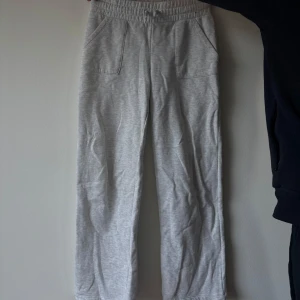 Grå mjukisbyxor från 157 - Grå mjukisbyxor från 157 med elastisk midja och dragsko. Byxorna har raka ben och två stora fickor framtill. Perfekta för chill dagar eller när du vill vara extra bekväm. Tillverkade i mjukt bomullsmaterial. Chansar på att det är storlek S eller M