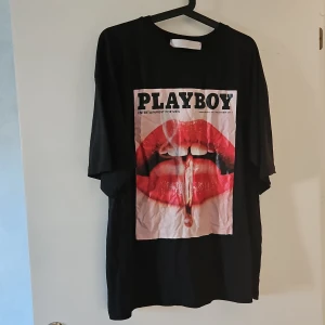 Svart Playboy x Missguided t-shirt - Cool svart t-shirt från Playboy x Missguided med stor tryckt graphic framtill.Perfekt statement-plagg för dig som gillar att sticka ut.Storlek M