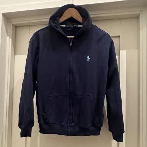 Ralph Lauren zip hoodie  - Säljer denna Ralph lauren tröjan. Zip hoodie. Den är i storlek M men passar bäst S.  Använd fåtal gånger och sparsamt. Inga defekter. 