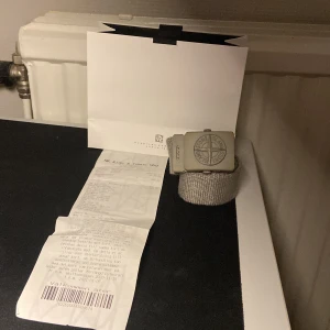  Stone Island junior bälte ljusgrön/beige - Snyggt junior bälte från Stone Island. Köpt på NK Göteborg. Det finns kvitto och box till.