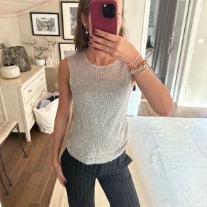 Silvrig stickad linnetopp från BikBok - Säljer en snygg silvrig stickad linnetopp från BikBok i storlek XS. Toppen är ärmlös med rund halsringning och har en glittrig känsla tack vare det metalliska garnet. Perfekt att styla med både jeans och kjol för en trendig look.