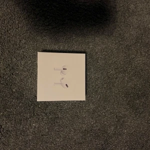 AirPods Pro - Apple AirPods Pro i mycket fint skick, komplett med originalförpackning, laddningsetui och laddningskabel. Trådlösa hörlurar med aktiv brusreducering och hög ljudkvalitet. Inga synliga repor eller skador, redo att användas direkt. Helt nya 