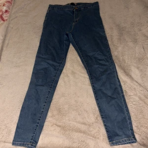 Blå skinny jeans från DenimCo - Snygga blå skinny jeans från DenimCo med klassisk femficksdesign och hög midja. Jeansen har smal passform hela vägen ner och är tillverkade i mjukt denimtyg med lätt stretch. Perfekta för dig som gillar en tight och stilren look.