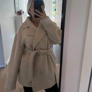 Beige kort kappa - Säljer denna kappa från NAKD då jag inte använder den längre, lite större i storleken. Är snvänd några gånger men i fint skick 💗💗
