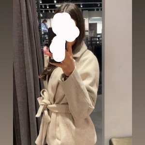 Beige kappa med bälte och krage - Snygg beige kappa med klassisk krage och knytskärp i midjan. Från veramoda, är i fint skick använt den några gånger bara 