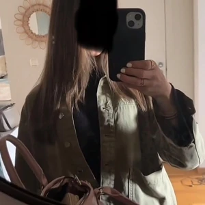 Olivgrön overshirt med knappar - Säljer en olivgrön overshirt med klassisk krage och knäppning framtill. Jackan har en loose passform och är tillverkad i bomull, perfekt att slänga över en hoodie eller t-shirt. Enkel och stilren design som funkar till det mesta.