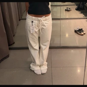 Zara low wide jeans - Vita låga jeans med knytning. Några små diskreta fläckar som inte märks av. Storlek 36