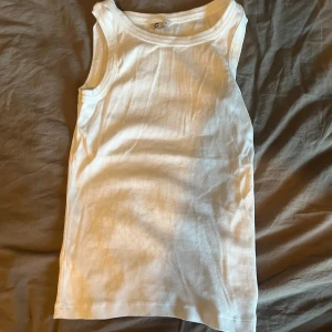 Vit ribbad linnetopp XS - Säljer en klassisk vit ribbad linnetopp från Cubus i storlek XS. Toppen är ärmlös med rund halsringning och har en tight passform. Perfekt att styla med jeans eller kjol för en clean look. Aldrig använd med har hängt i garderoben i nått år