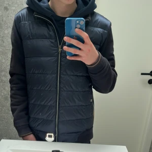 Mörkblå cardigan från Herno - Säljer en snygg mörkblå Cardigan från Herno med dragkedja och quiltad design. Cardiganen har en stilren look och passar perfekt för kommande sommar kvällar. Skick 9/10 NYSKICK🤩skriv vid minsta fundering eller för fler bilder!