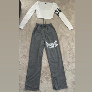 Mjukisset med Los Angeles tryck  - Gråa mjukisbyxor med vitt Los Angeles-tryck på ena benet. Byxorna har resår och snörning i midjan för skön passform och raka, lösa ben. Kommer med en vit magtröja med likadant tryck på ena armen. Bara testat på dvs inte använd alls, säljer pga för liten på mig. För frågor eller funderingar är det bara att höra av sig ☺️🌸