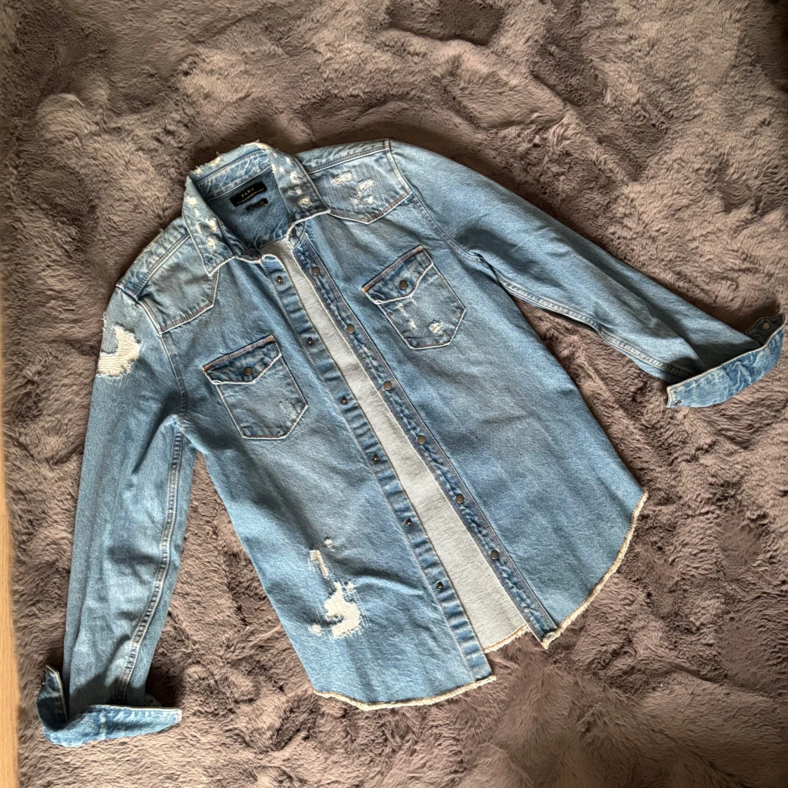 Ljusblå jeansskjorta med slitningar