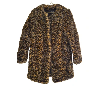 Leopardmönstrad pälsjacka (fuskpäls) - Säljer en fluffig och trendig pälsjacka från Kappahl med leopardmönster. Jackan har lång ärm, rak passform och har en mjuk insida. Jackan är ej i äkta päls. (höstjacka/animal print/trenchcoat/kappa/lång jacka)