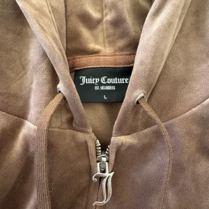 Brun velour set från Juicy Couture - Mysig brun hoodie och byxa från Juicy Couture i mjuk velour. Koftan är i strl L och byxorna i XL (sitter mer som L). Köptes för 2 400 kr. Använts några gånger, men inget som märks av. Säljer båda för 900. ❣️
