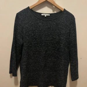 Mörkblå stickad tröja från Flash Woman - Mysig mörkblå stickad tröja från Flash Woman i storlek S. Tröjan har ett melerat mönster i blått och vitt, rund halsringning och trekvartsärm. Baksidan har en snygg omlott-detalj som ger en extra touch till looken. Frakt ingår ej💕