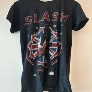 Svart Slash Turnétröja - Dels pga flytt och dels pga att denna tröjan inte passar mig längre så säljer jag denna snygga turnétröjan som jag köpte när jag såg Slash på Gröna Lund för ca tio år sedan. Den har använts en del så trycket är lite slitet, men i övrigt är tröjan i bra skick.